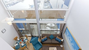 Apartamento alto com varanda, área de refeições, sofá e um quadro.
