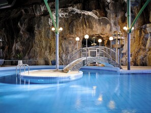 A swimming pool with a stone bridge, metal railings, and a tiled deck. - Holiday Club Tampereen Kehräämö Apartments (Tampere)