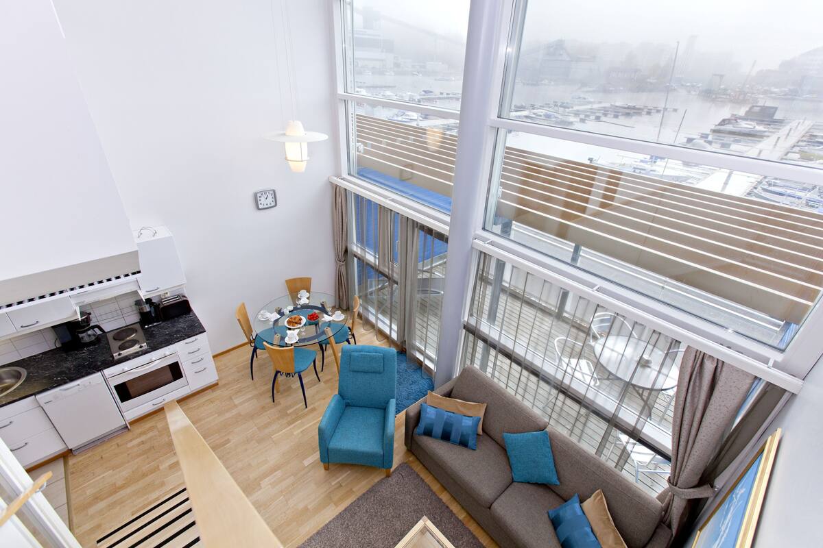 A modern apartment with a kitchen, dining area, and living room with large windows.