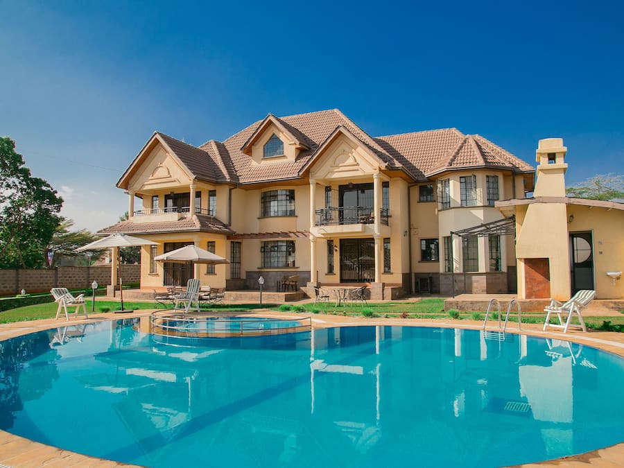 Een buitenzwembad, ligstoelen bij het zwembad