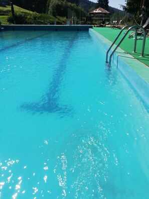 Una piscina cubierta, una piscina al aire libre de temporada, sombrillas