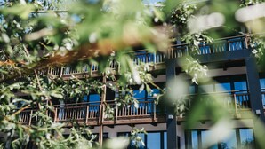 A multi-story building with balconies and large windows. - Hotel Chesa Monte (Fiss)