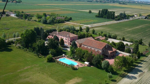 An aerial view of a large estate with a swimming pool, multiple buildings, and expansive green fields. - Bordeghina B&B in Farmhouse (Pontecchio Polesine)