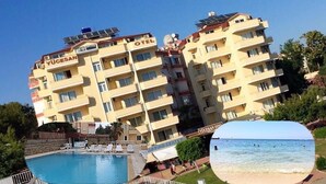 Un hotel de diverses plantes amb balcons, una piscina i vistes a la platja.