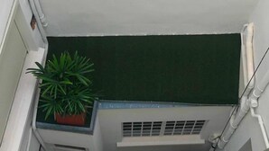 A corner of a building with a green artificial turf roof, a potted plant, and white exterior walls. - Hôtel Saint Patrick Cœur de NANTES (Nantes)