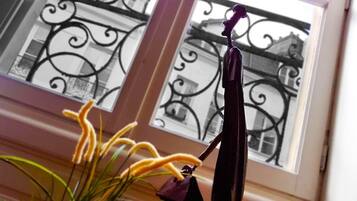 A room with a view of a balcony with wrought iron railings and a window.