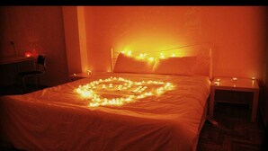Una cama con una decoración de luces en forma de corazón sobre el edredón.