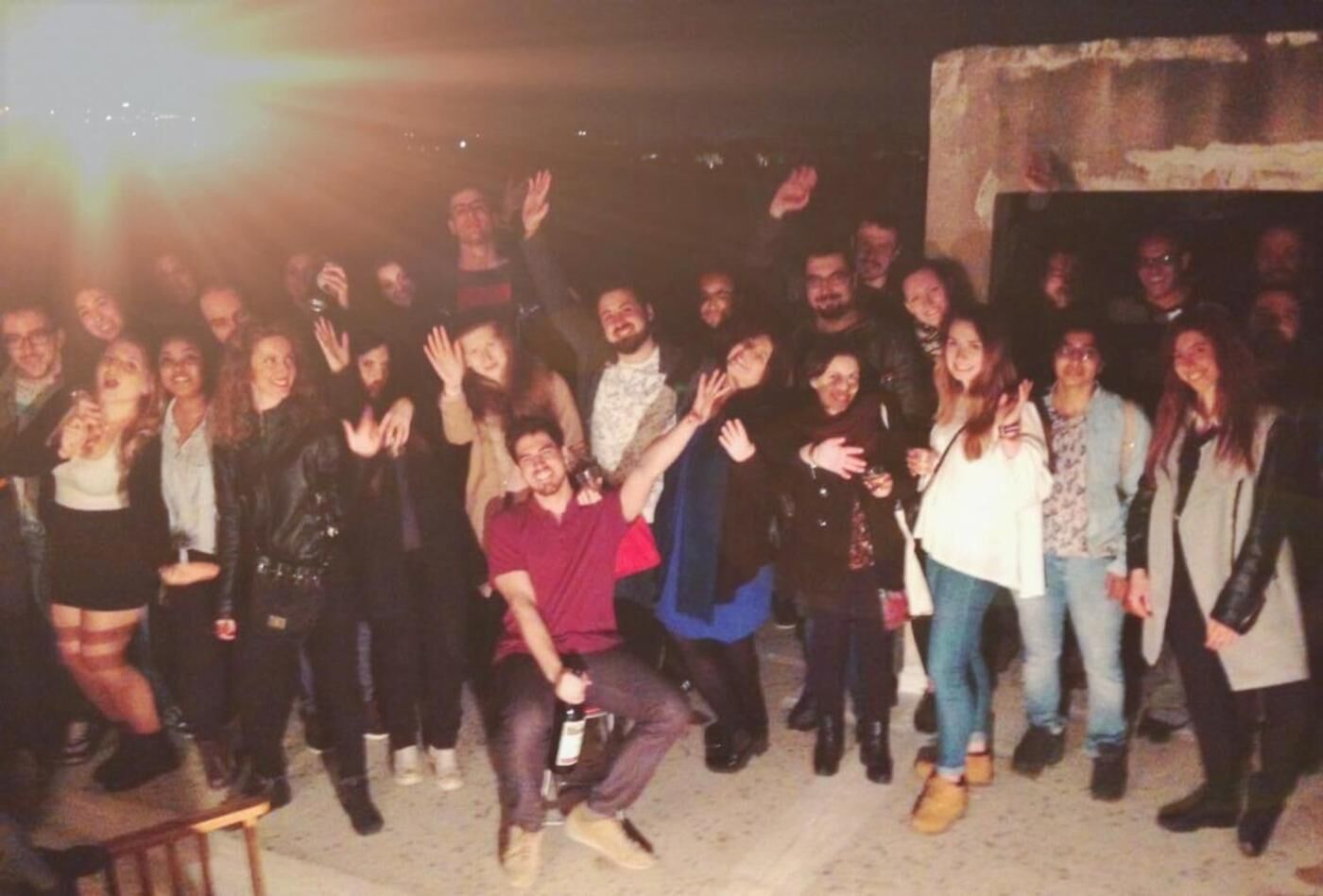 Eine Gruppe von Personen posiert für ein Foto vor einer Betonstruktur im Freien.
