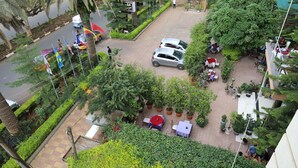 Une cour d’hôtel avec un chemin pavé, des plantes en pot et des espaces aménagés pour s’asseoir à l’extérieur.