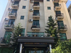 A multi-story hotel with balconies, air conditioning units, and a sign reading "JACARANDA HOTEL". - Jacaranda Hotel (Bahir Dar)