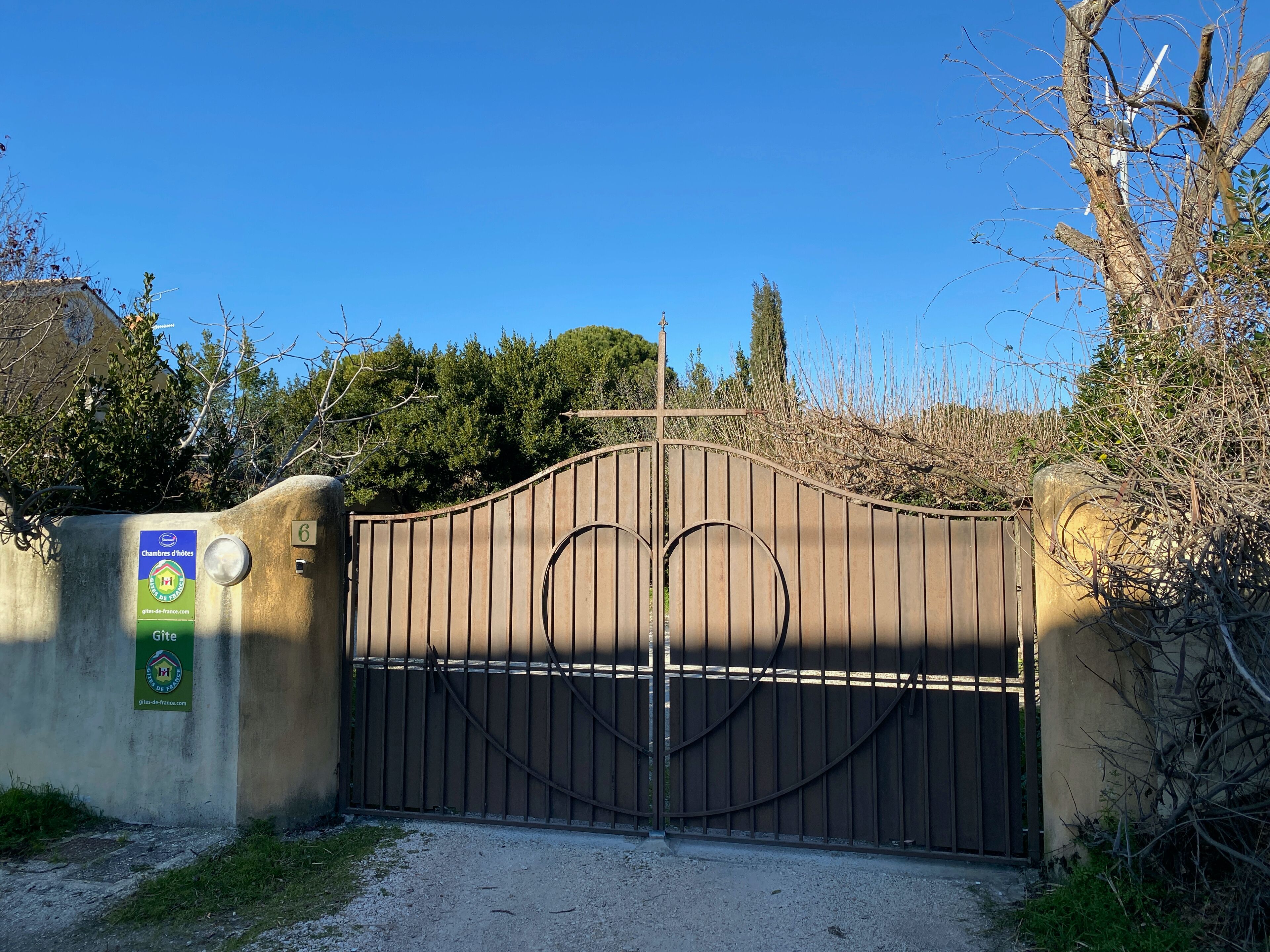 A gated entrance with a sign indicating 'Chambres d'hotes' and 'Gîte'.