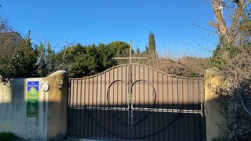 A gated entrance with a sign indicating 'Chambres d'hotes' and 'Gîte'.