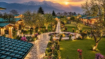 A resort with multiple buildings, a central pathway, and a mountainous backdrop.