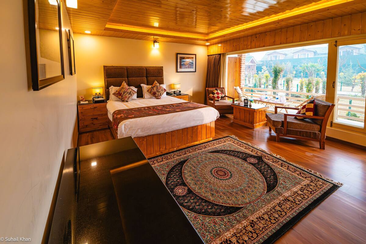 Um quarto espaçoso com uma cama grande, uma escrivaninha e vista para o exterior.