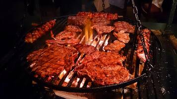 A grill with various meats being cooked.