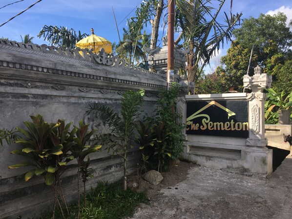 A sign with "The Semeton" written on it, surrounded by greenery and a decorative wall. - Semeton Homestay (Senggigi)