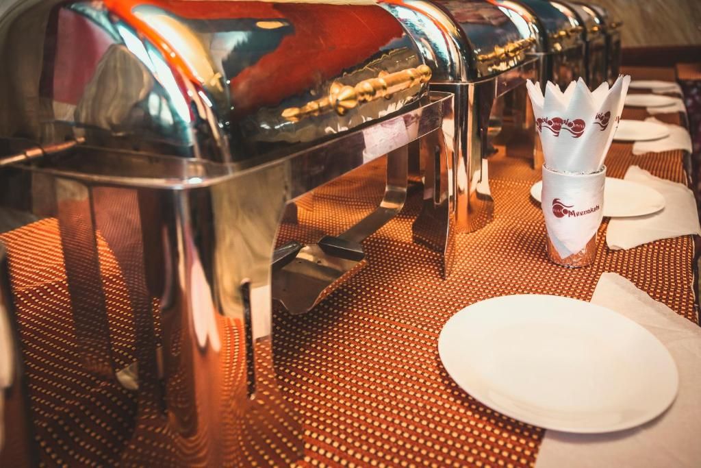 A buffet setup with multiple serving stations and a napkin holder.