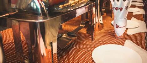 A buffet setup with multiple serving stations and a napkin holder.