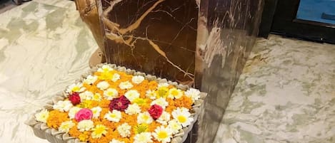 A marble column with a flower arrangement at its base.