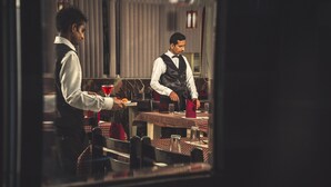 A restaurant interior with tables, chairs, and waitstaff. - Hotel Meenakshi Udaipur (Udaipur)