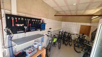 Een werkplaats met gereedschap, fietsen en een werkbank.