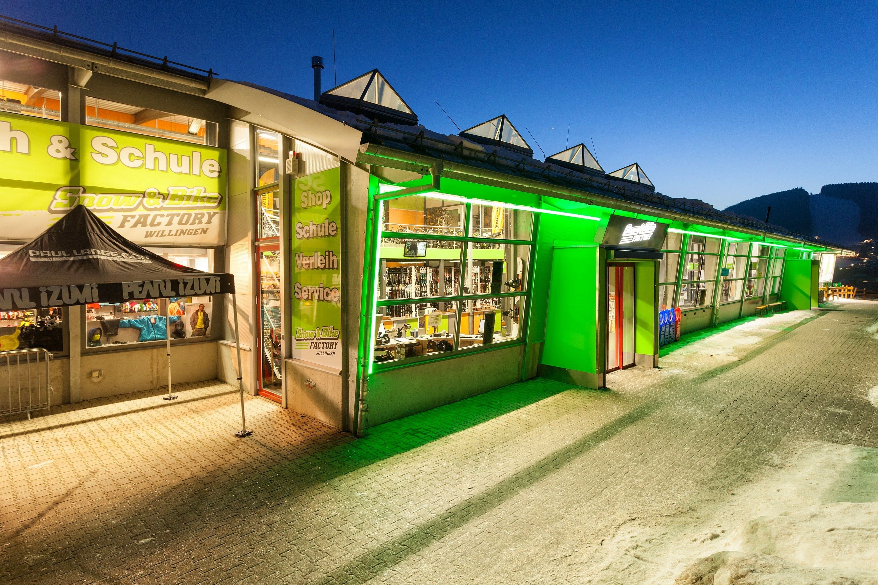 Un escaparate iluminado con un letrero de neón verde y un escaparate visible.