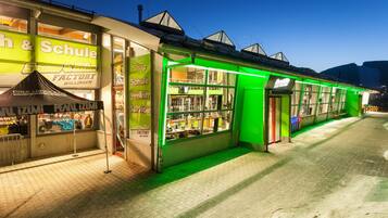 Un escaparate iluminado con un letrero de neón verde y un escaparate visible.