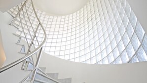 Uma escadaria em espiral com teto de vidro, permitindo que a luz natural ilumine o interior.