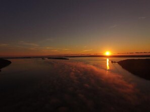 A sunset over a calm body of water with a clear sky. - Patterson Bay Cottage 3 (Spring Bay)