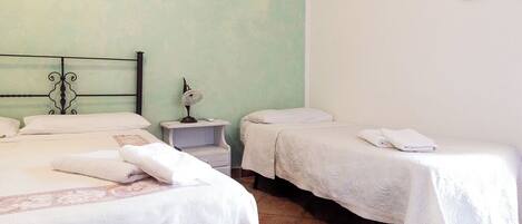 Una habitación de hotel con dos camas, una mesita de noche y un reloj de pared.