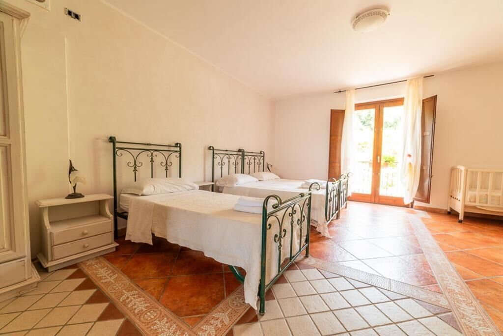 Ein Schlafzimmer mit zwei Betten, einem Nachttisch und einem großen Fenster.
