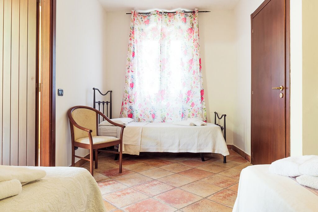 Une chambre à coucher avec un lit, une chaise et une porte en bois.