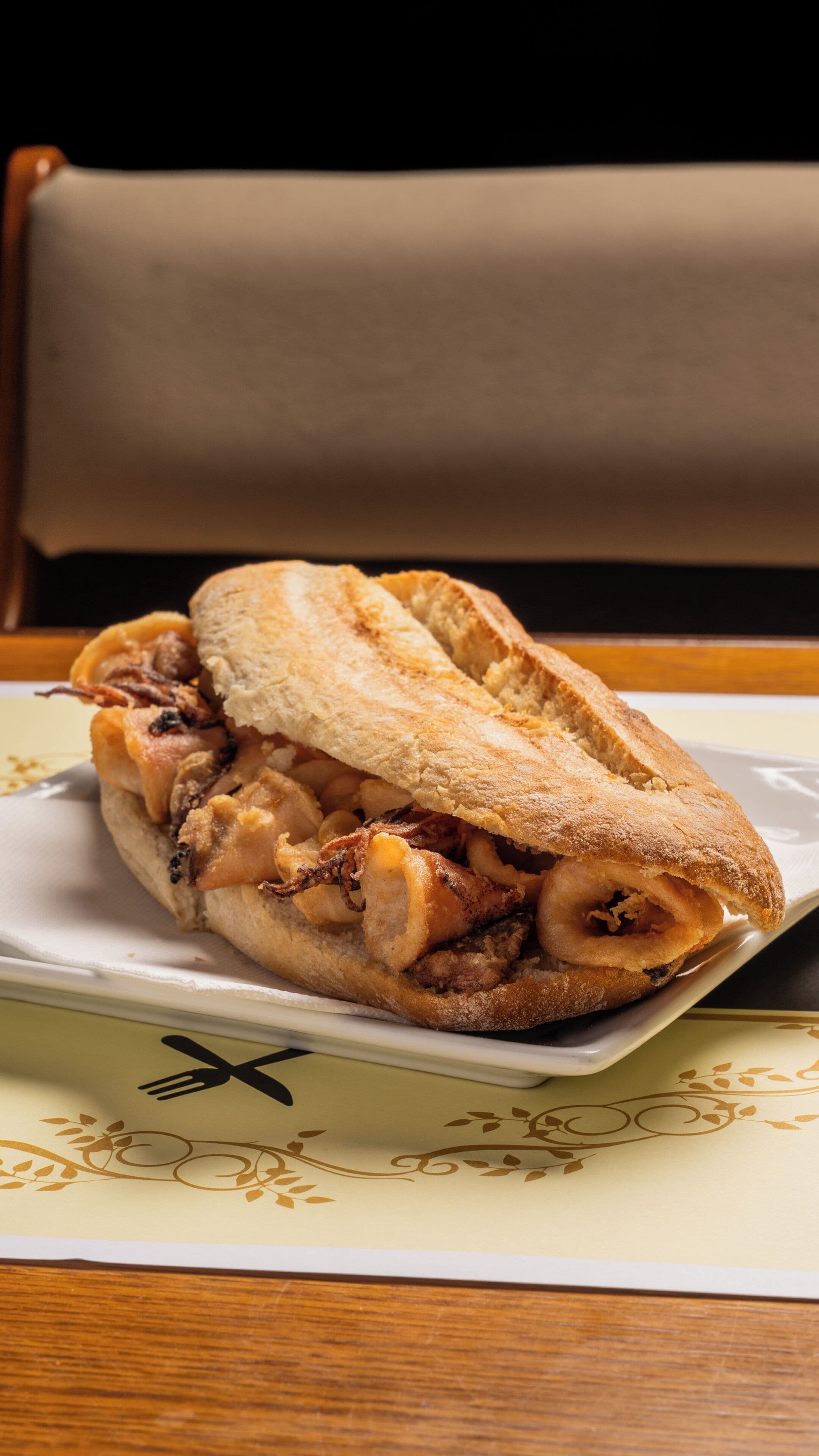 A sandwich on a plate with a napkin underneath.