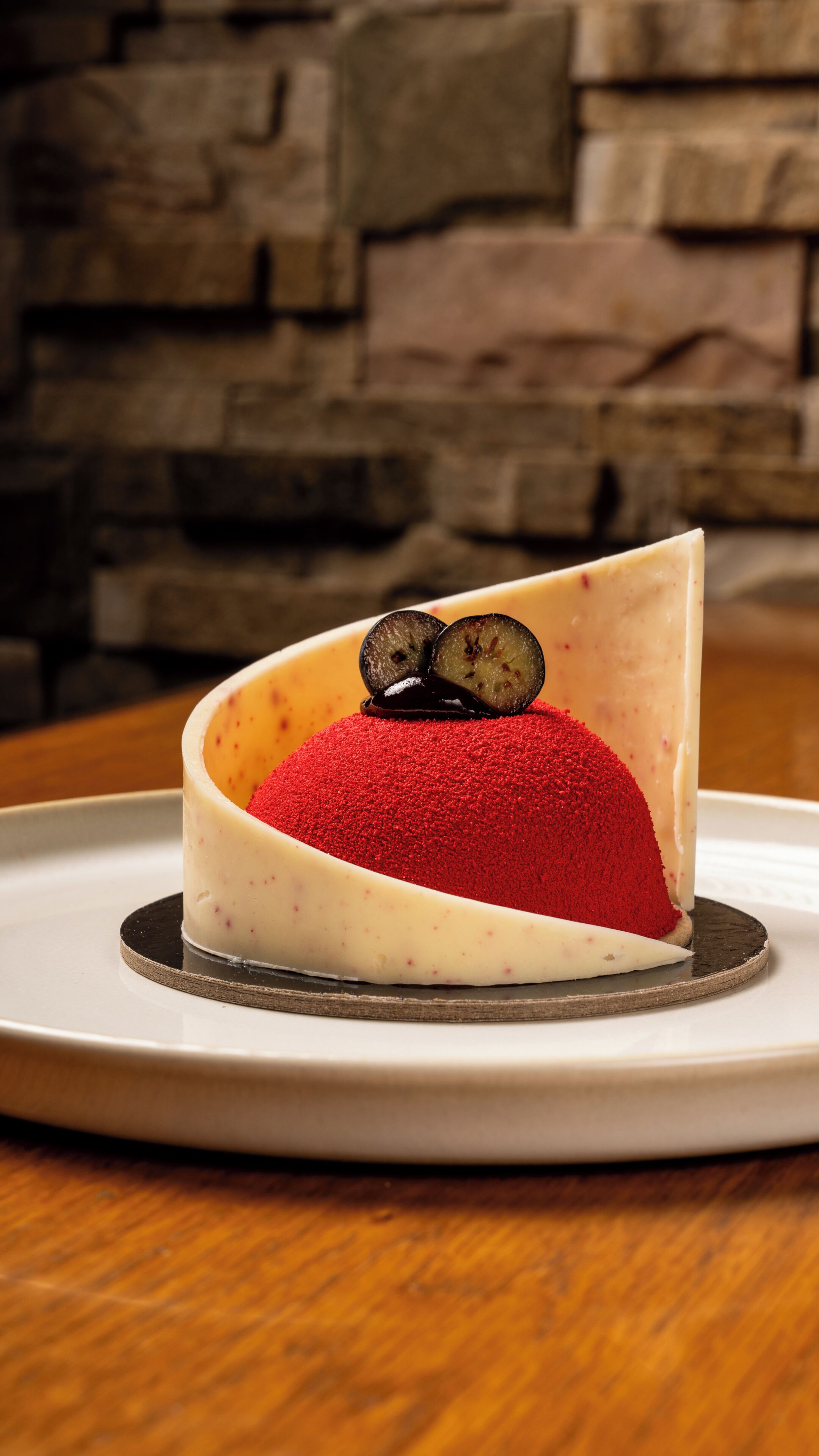 Un postre con cobertura de polvo rojo y dos mitades de berenjena sobre un plato.