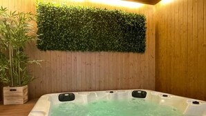 A hot tub with green water, surrounded by wooden walls and a green wall decoration.