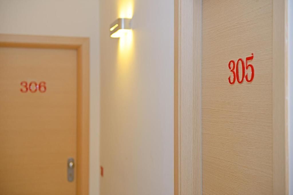 Kaksi ovea, joissa on numerot 306 ja 305, ja jotka osoittavat huoneiden numerot.