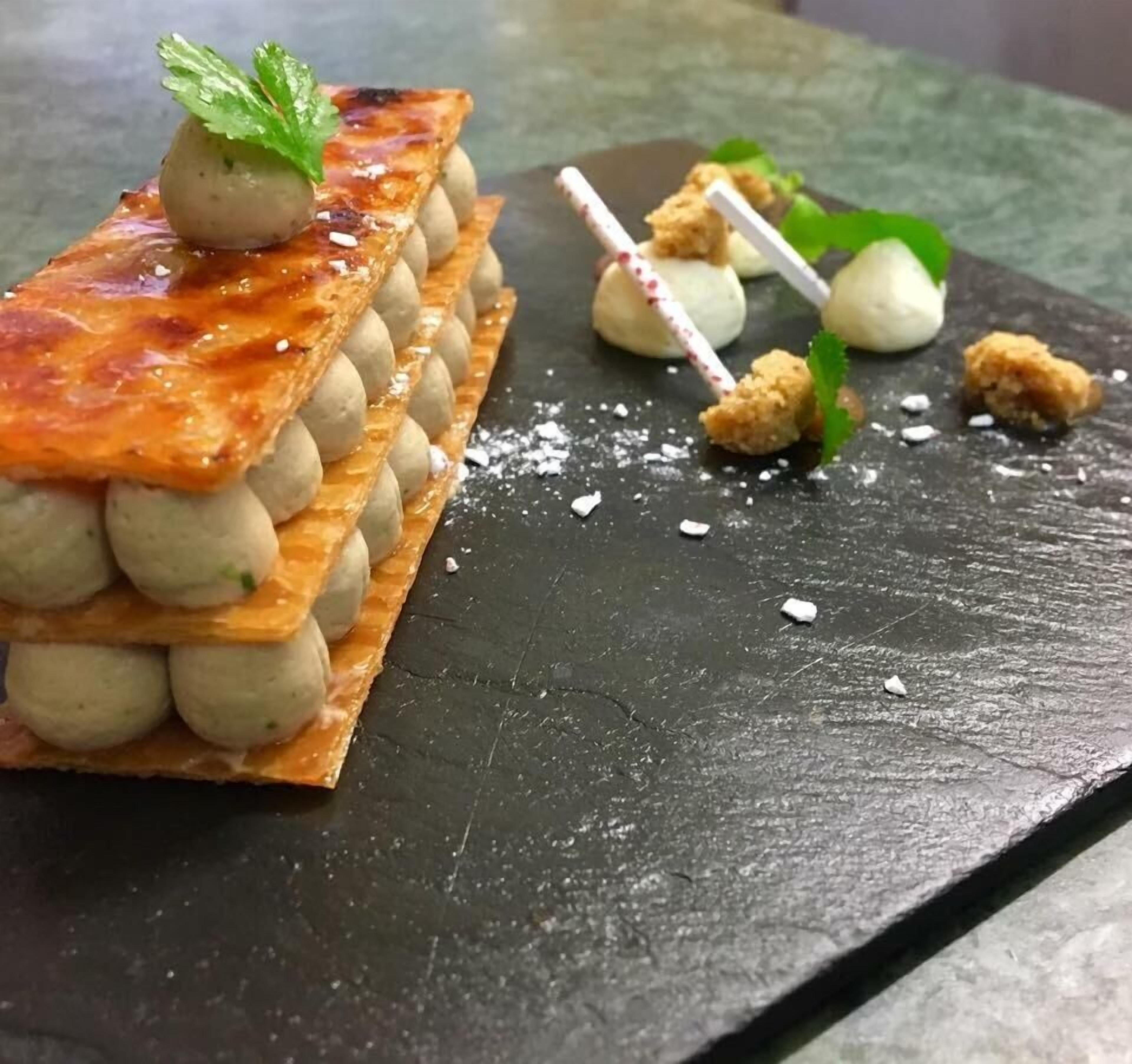 Ein Dessert mit rechteckiger Basis, runden Kugeln und einer Minzgarnitur.