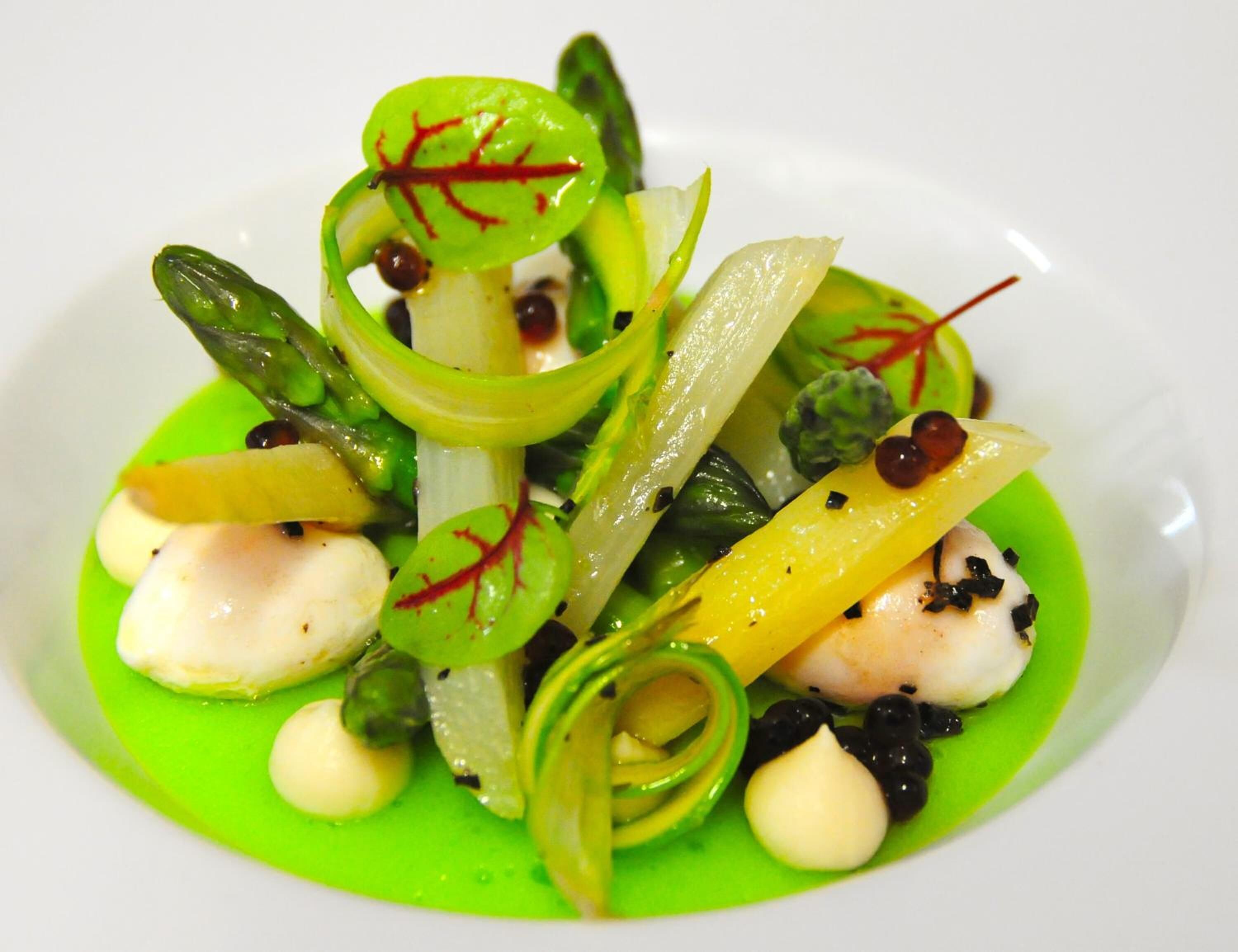 A plate of food with various vegetables and a green sauce.