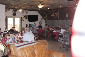A restaurant with wooden ceilings, mounted animal heads, and a large stove. - Monster Lake Ranch (Cody)