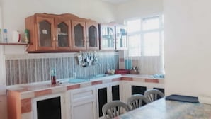 Cozinha com armários de madeira, micro-ondas e janela.