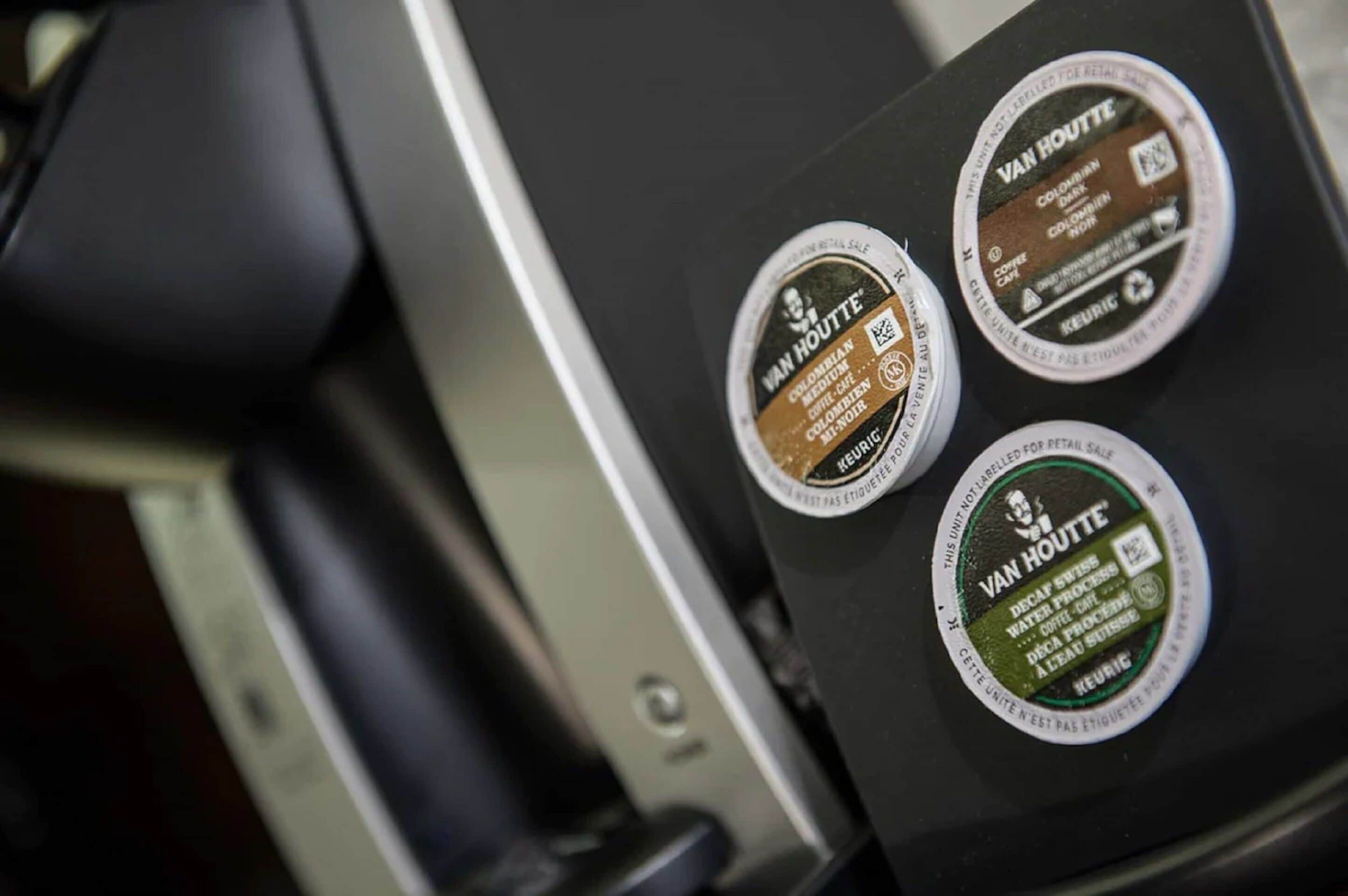 A coffee machine with three coffee pods labeled 'Van Houtte'.