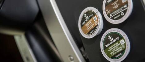 A coffee machine with three coffee pods labeled 'Van Houtte'.