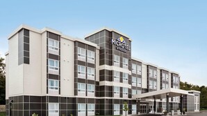 Ein Microtel Wyndham Hotel mit modernem Design, inklusive Parkplatz und überdachter Zufahrt.