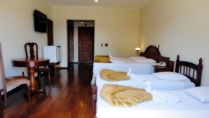 A hotel room with two single beds, a wooden chair, a small table, and a television on the wall. - JS Park Hotel (Sao Lourenco)