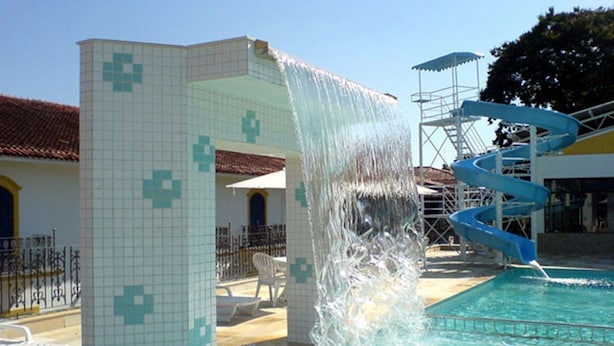 A pool area with a water slide and a tiled structure. - JS Park Hotel (Sao Lourenco)