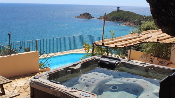 A hot tub with a view of the ocean and a rocky island. - Villa with pool and private Spa facing the sea (Conca)