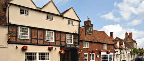 A traditional pub with a white facade and timber framing, featuring a sign that reads "The White Lion."