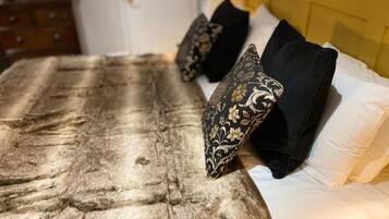 Un lit recouvert d’une couverture qui ressemble à de la fourrure, et agrémenté d’oreillers aux motifs noirs et dorés.
