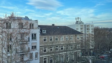 A multi-story building with a mix of residential and commercial spaces, featuring balconies, large windows, and a visible satellite dish.