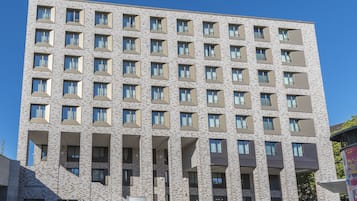 A multi-story building with a uniform facade, rectangular windows, and a central entrance.